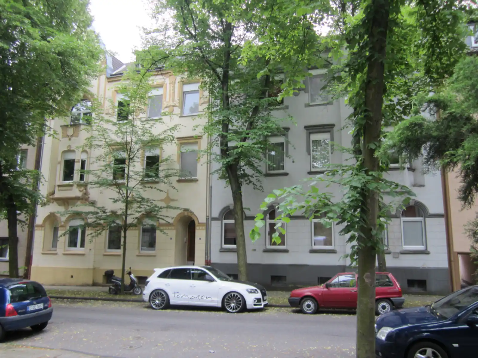 Zwei Altbau-Wohnhäuser mit hellen Putzfassaden an der Radhoffstraße in Essen-Altenessen-Süd, davor Bäume und Autos