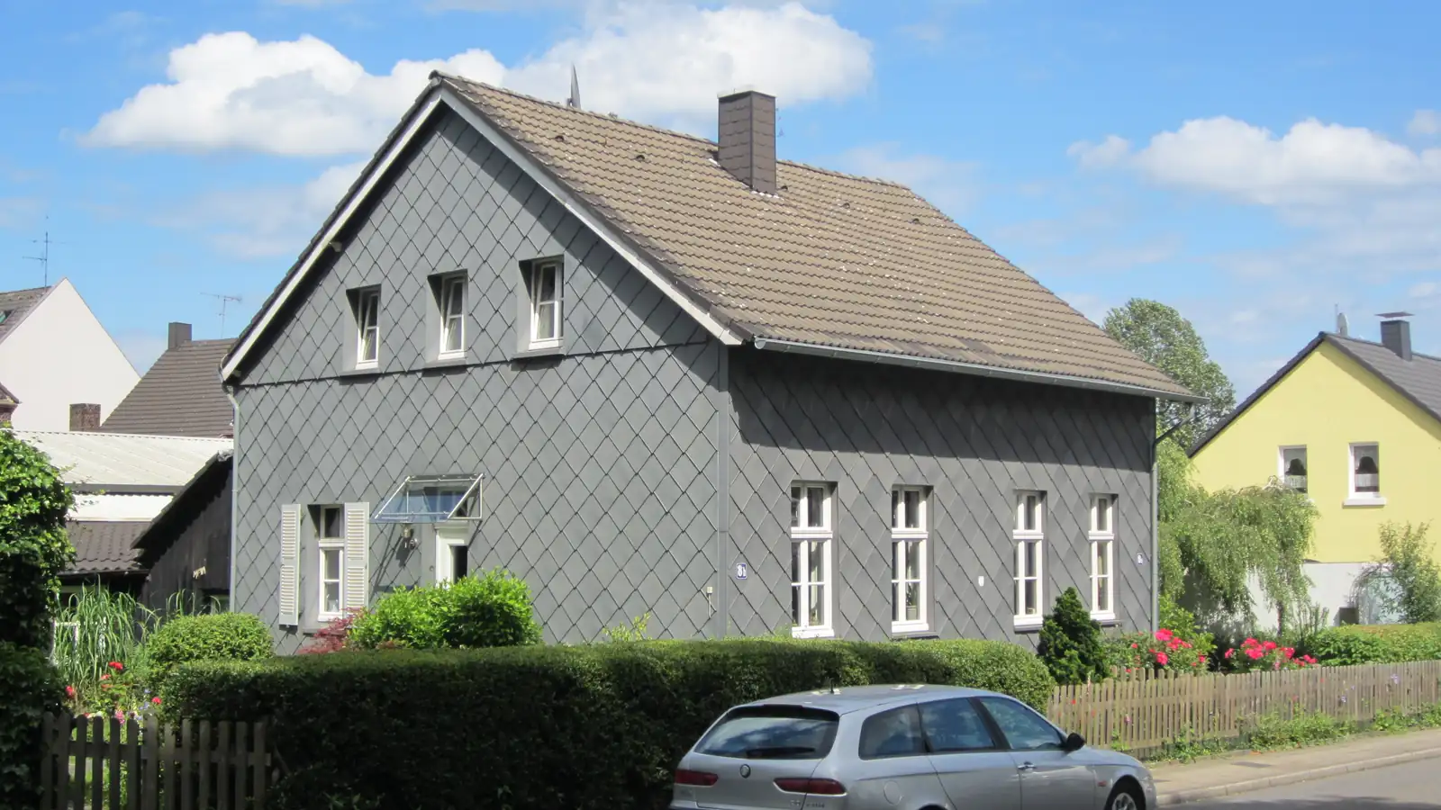 Zweigeschossiges Wohnhaus mit grauer Schieferfassade und Satteldach an der Wachtstraße in Essen-Borbeck-Mitte
