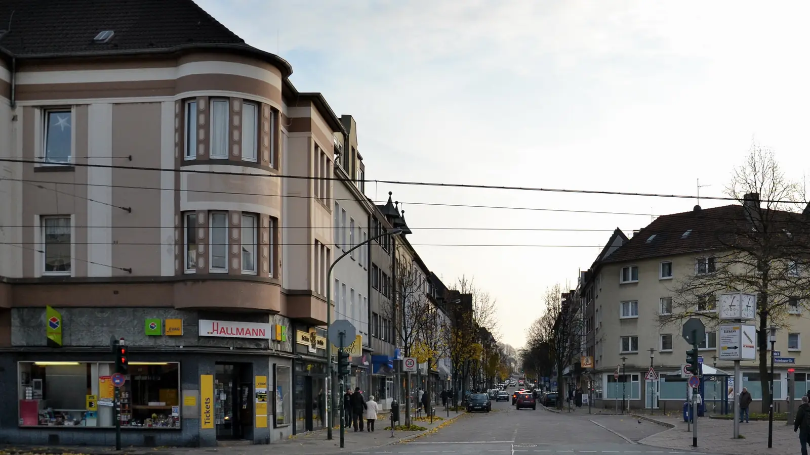 Berliner Straße in Essen-Frohnhausen mit mehrgeschossigen Wohn- und Geschäftshäusern, Kreuzung und Ampel im Vordergrund
