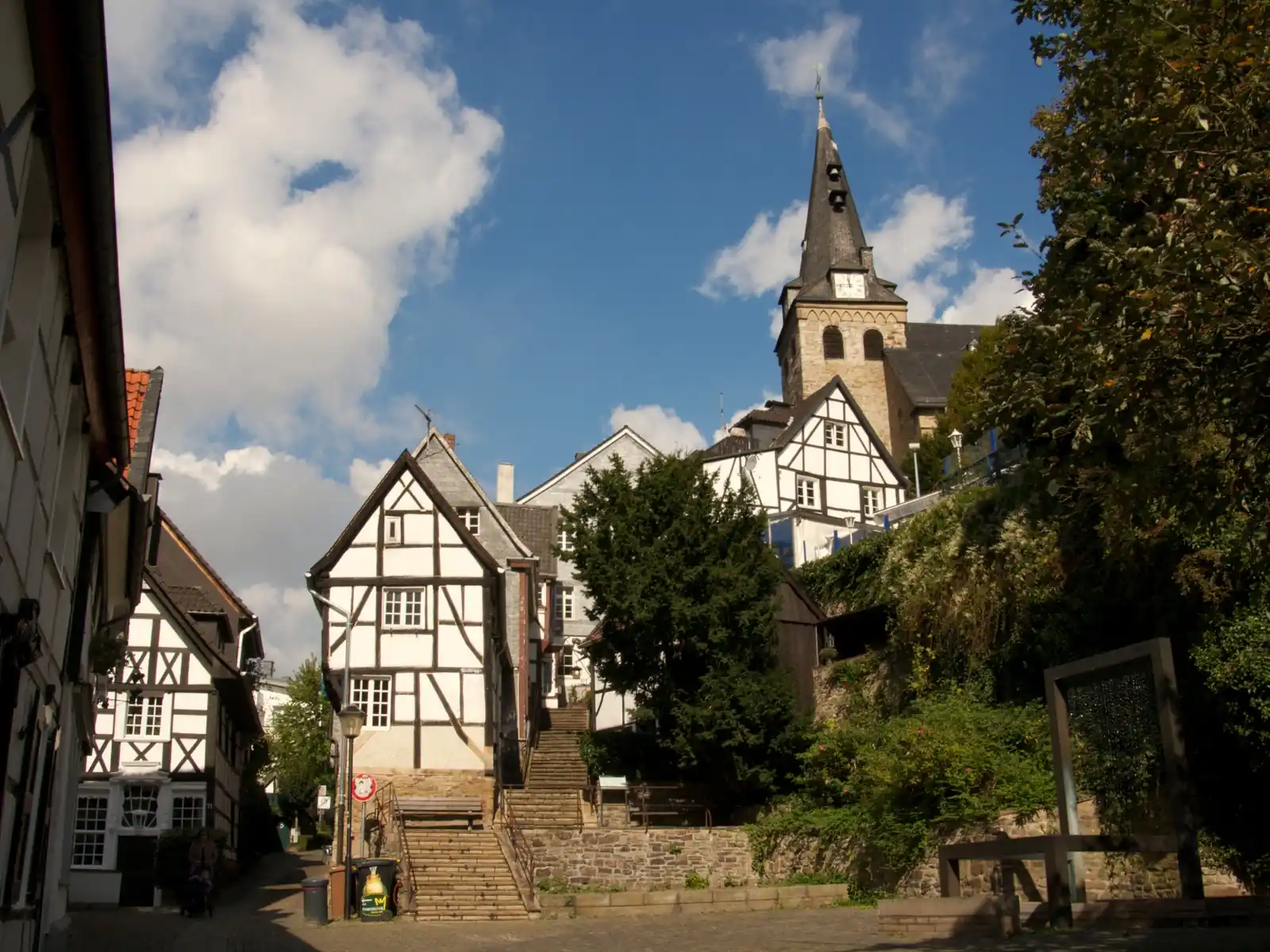 Tuchmacherplatz in Essen-Kettwig mit Fachwerkhäusern an der Kirchtreppe und dem Turm der Kirche am Markt dahinter