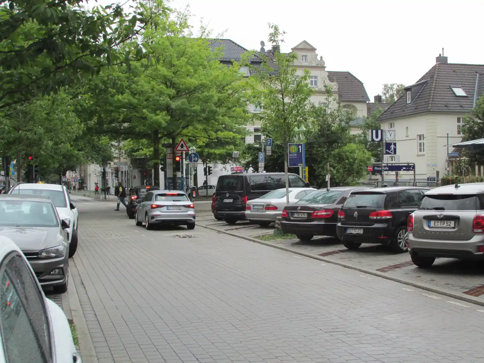 Rüttenscheider Straße in Essen an der Haltestelle Florastraße mit Altbauten, Straßenbäumen und dicht geparkten Autos