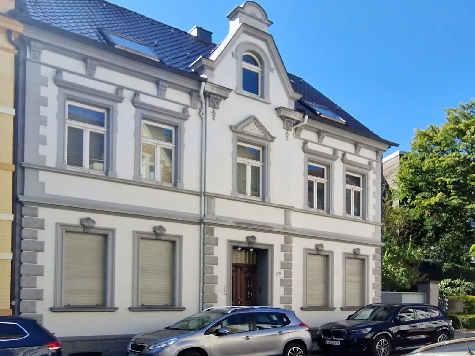 Denkmalgeschütztes Wohnhaus an der Propsteistraße in Essen-Werden mit heller Stuckfassade und Ziergiebel über dem Eingang